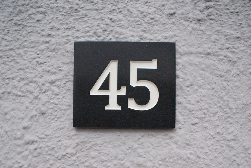 Black plaque with the number 45 on a textured wall, corian sign - night sky- Natural Signs